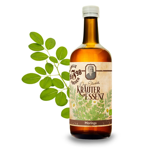 Braune Glasflasche mit Etikett "Kräuter Essenz" und grünen Blättern im Hintergrund.