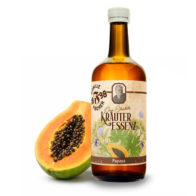 Braune Flasche mit Etikett "Kräuter Essenz" neben einer halbierten Papaya.
