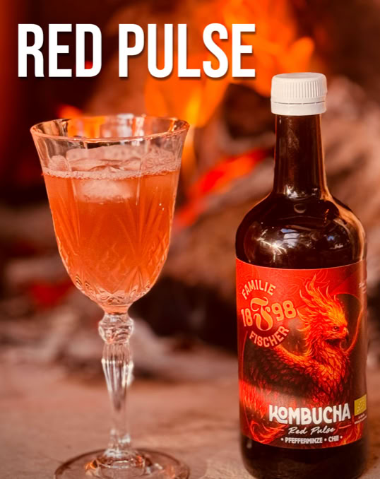 Ein Glas mit rotem Getränk und eine Flasche mit rotem Etikett, auf dem ein Drache abgebildet ist, vor einem unscharfen Hintergrund mit Feuer. Text "RED PULSE" oben links.