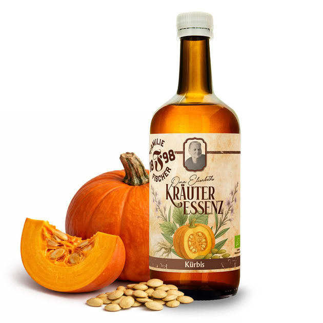Eine Flasche Kräuteressenz neben einem Kürbis, einem Kürbisstück und Kürbiskernen.