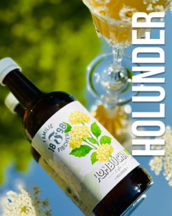 Eine Flasche mit einem Etikett, das Holunderblüten zeigt, neben einem gefüllten Glas und dem Wort "HOLUNDER" in großen Buchstaben.