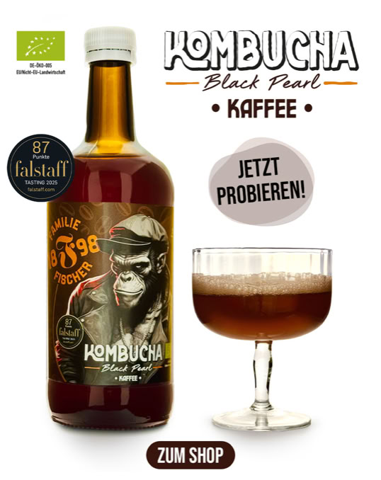 Eine Flasche Kombucha mit einem Etikett, das einen Affen zeigt, neben einem Glas mit dunkler Flüssigkeit. Text auf dem Bild: "Kombucha Black Pearl Kaffee", "Jetzt probieren!", "Zum Shop".